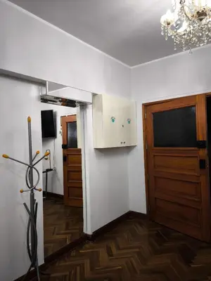 a room with a door and a television and a chandelier at Lindo apartmento en PLAZA PRINCIPAL in Lima