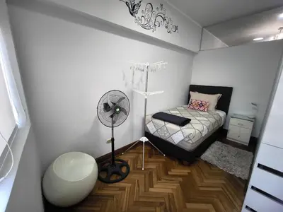 a small bedroom with a bed and a fan at Lindo apartmento en PLAZA PRINCIPAL in Lima