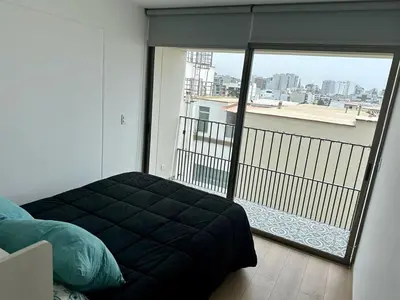 a bedroom with a bed and a balcony with a view at No available in Lima