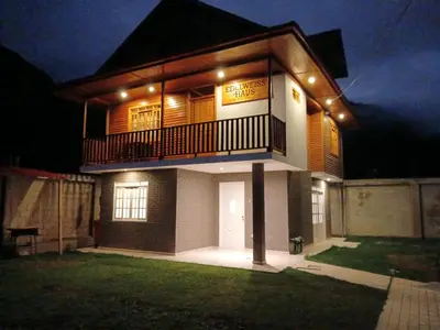 a house with a balcony with lights on it at Edelweisshaus Chontabamba in Oxapampa