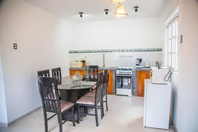 a kitchen with a table and chairs and a refrigerator at Edelweisshaus Chontabamba in Oxapampa