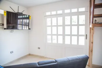 a living room with a couch and a sliding door at Edelweisshaus Chontabamba in Oxapampa