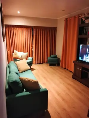 a living room with a green couch and a flat screen tv at Centrally located across Magic Water Park Circuit - LIMA - PERU in Lima