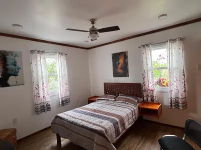 a bedroom with a bed and two windows at Villa Aurora in Aucallama