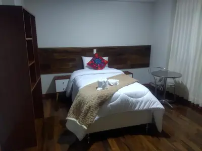 a bedroom with a bed with two towels on it at Retama Lodging in Cusco