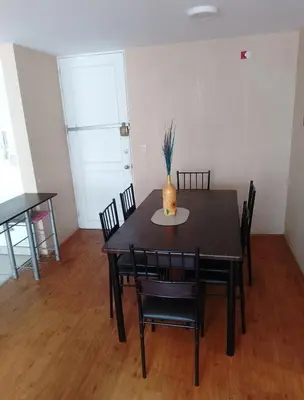 a dining room table and chairs with a vase on it at Alquilo Departamento en Comas in Lima