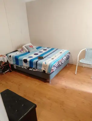 a small bedroom with a bed and a chair at Alquilo Departamento en Comas in Lima