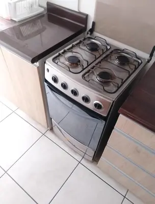 a stove top oven sitting in a kitchen at Alquilo Departamento en Comas in Lima