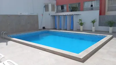 a swimming pool in the middle of a building at Departamento con piscina ubicado en Breña in Lima