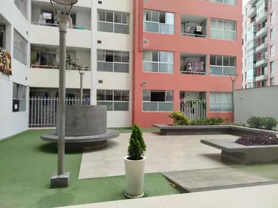 a courtyard of an apartment building with a potted plant at Departamento con piscina ubicado en Breña in Lima