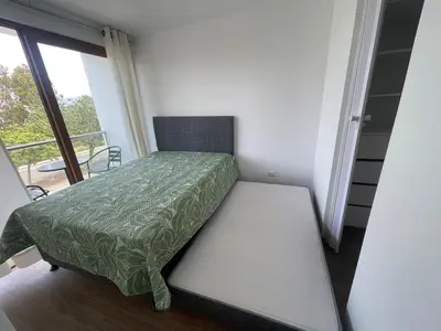 a small bedroom with a bed and a balcony at Casa de campo en condo cerca a playa Puerto Viejo in San Antonio