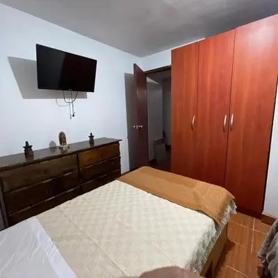 a bedroom with a bed and a flat screen tv at Cuarto A en La Warida House in Ayacucho