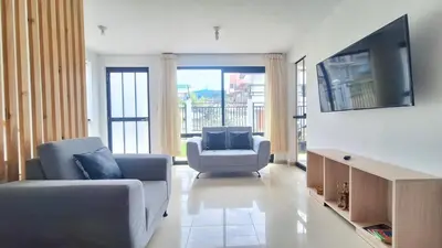 a living room with two chairs and a flat screen tv at Casa Qiru tu Refugio en Oxapampa in Oxapampa