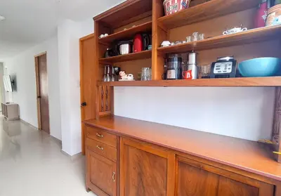 a kitchen with a wooden cabinet and shelves at Casa Qiru tu Refugio en Oxapampa in Oxapampa