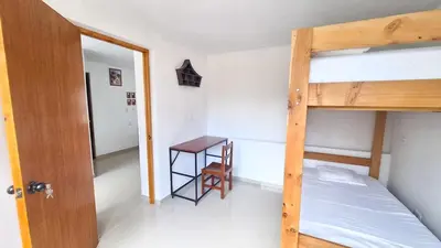 a bedroom with a bunk bed and a desk at Casa Qiru tu Refugio en Oxapampa in Oxapampa