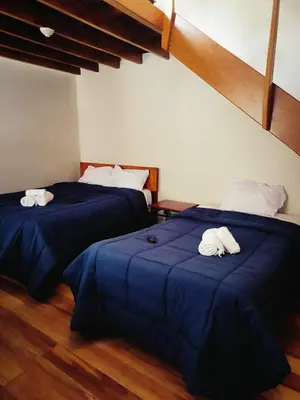 two beds in a room with blue sheets and towels at Casa Centro Historico Cusco in Cusco
