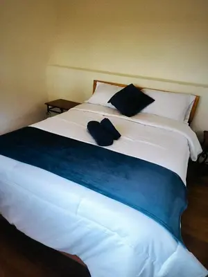 a large white bed with two blue pillows on it at Casa Centro Historico Cusco in Cusco