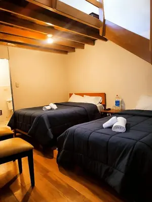 two beds in a hotel room with towels on them at Casa Centro Historico Cusco in Cusco