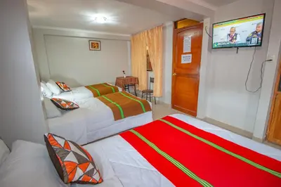 a bedroom with two beds and a flat screen tv at AloInkaHotels in Cusco