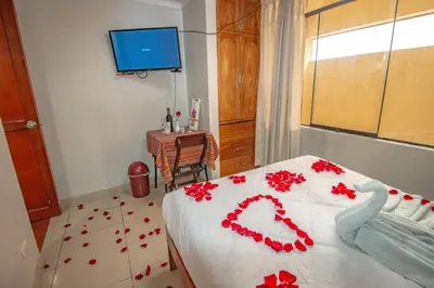 a bedroom with a bed with red flowers on the floor at AloInkaHotels in Cusco