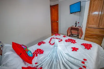 a bed with red flowers on it in a bedroom at AloInkaHotels in Cusco