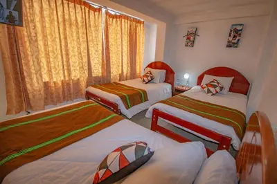 a hotel room with two beds and a window at AloInkaHotels in Cusco