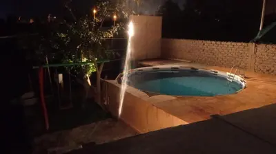 a swimming pool at night with a water fountain at Casa EN ASIA in Asia