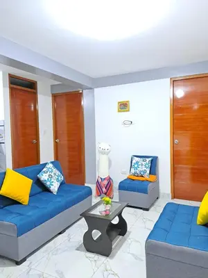 a living room with two blue couches and a table at Samin House in Cusco