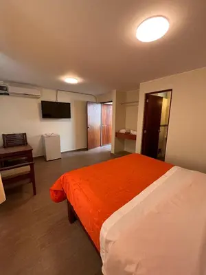 a bedroom with a large bed with an orange blanket at Boulevard Hotel in Asia