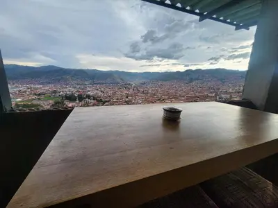 a coffee cup sitting on a wooden table in a window at Casa Mirador SanBlas Quilla in Cusco