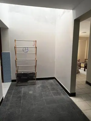 a room with a white wall and a tile floor at Dpto Familiar en San Bartolo in San Bartolo