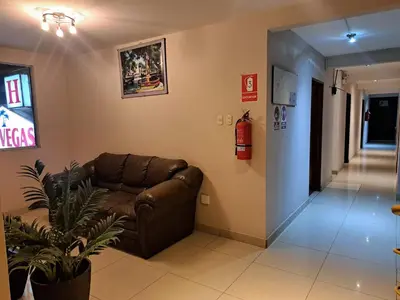 a living room with a couch and a fire extinguisher at Hospedaje Las Vegas in San Vicente de Cañete