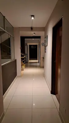 a hallway with white tile floors in a building at Hospedaje Las Vegas in San Vicente de Cañete