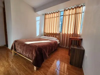 a bedroom with a bed and two windows at Sol de América in La Unión
