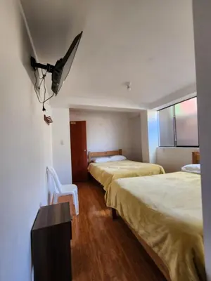 a room with two beds and a chair in it at Sol de América in La Unión