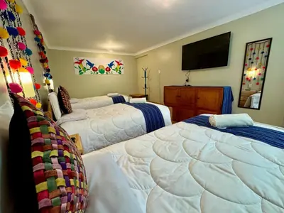 a bedroom with two beds and a flat screen tv at Tika house in Cusco