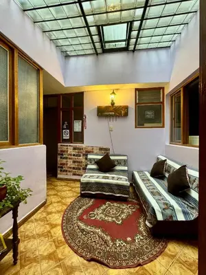 a living room with two beds and a rug at Tika house in Cusco