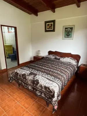 a bedroom with a bed with a blanket on it at Swiss Chalet en Canta in San Miguel