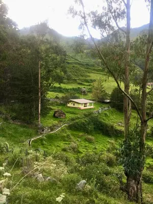 a house in the middle of a green field at Swiss Chalet en Canta in San Miguel