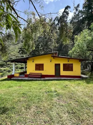 a yellow house with a large yard in front of it at Swiss Chalet en Canta in San Miguel