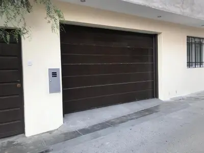 a black garage door on a white building at Albano apartamento 3 en tu refugio Chosica in Chosica