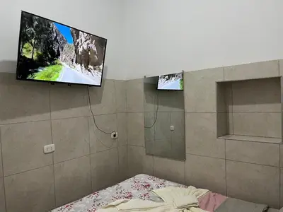 a bedroom with a bed and a flat screen tv at Albano apartamento 3 en tu refugio Chosica in Chosica