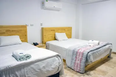 a bedroom with two beds with towels on them at Hotel Boutique La Angostura II in Ica
