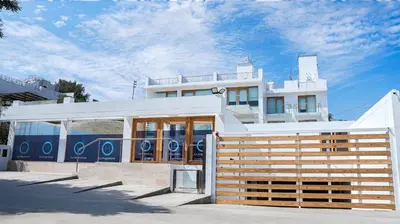 a white building with a fence in front of it at Hotel Boutique La Angostura II in Ica