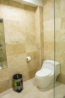 a bathroom with a toilet and a glass shower at Hotel Boutique La Angostura II in Ica