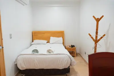 a bedroom with a bed with two cats on it at Hotel Boutique La Angostura II in Ica