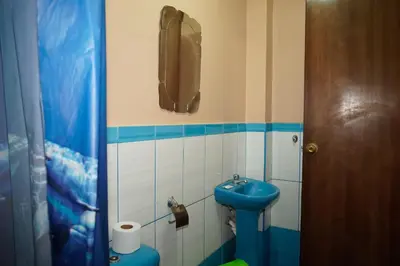a small bathroom with a blue sink and a phone at Hostal Luren - Parking in Nazca