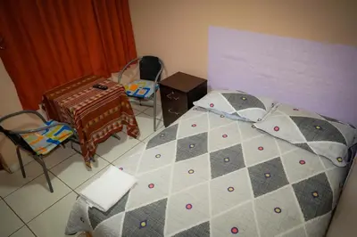 a bedroom with a bed and a table and chairs at Hostal Luren - Parking in Nazca