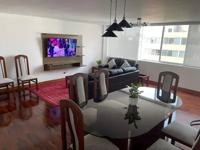 a living room with a couch and a table at Dpto Benavides la paz miraflores in Lima