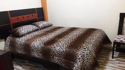 a bedroom with a bed with a leopard print blanket at Hospedaje Samarina in Acobamba